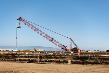 Fototapeta na wymiar Mobile crane at construction site against blue sky.