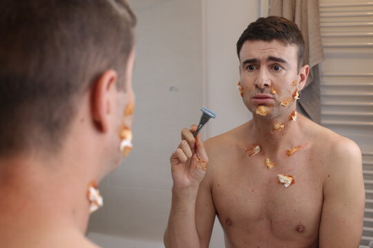 Humorous image of clumsy man shaving his beard 