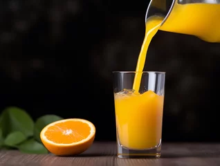 Fototapeten Orange juice being poured into a glass with fresh fruit on wooden background © Medard