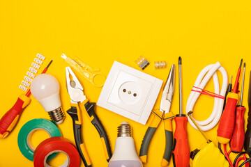 Electrician equipment on yellow background with copy space.Top view.Electrician tool set.Multimeter, tester,screwdrivers,cutters,duct tape,lamps,tape measure and wires.Flet lay. © Avocado_studio