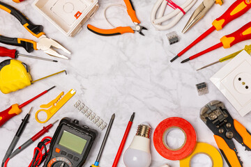 Electrician equipment on white background with copy space.Top view.Electrician tool set.Multimeter, tester,screwdrivers,wire pliers,duct tape, lamps, tape measure and wires.Flet lay. © Avocado_studio