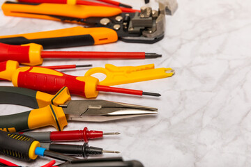 Electrician equipment on white background with copy space.Top view.Electrician tool set.Multimeter, tester,screwdrivers,wire pliers,duct tape, lamps, tape measure and wires.Flet lay. © Avocado_studio