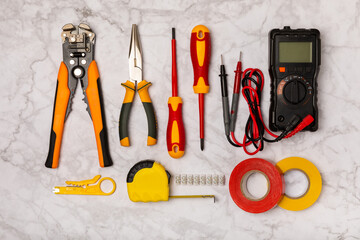 Electrician equipment on white background with copy space.Top view.Electrician tool set.Multimeter, tester,screwdrivers,wire pliers,duct tape, lamps, tape measure and wires.Flet lay. © Avocado_studio
