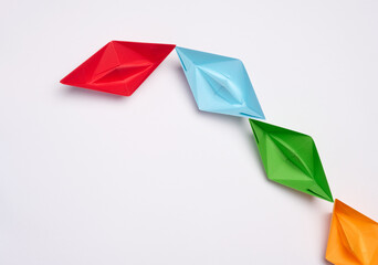Group of paper boats on a white background.Concept of a strong leader in a team, manipulation of...