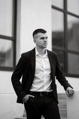 portrait of a young guy groom in a dark wool suit