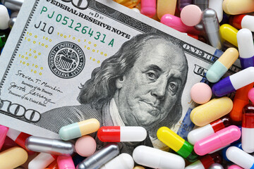 Pills on money dollars - Medicine prescription drugs cost concept - healthcare insurance expenses 