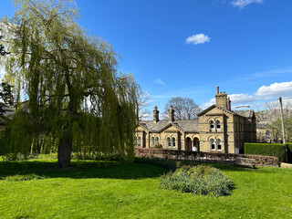 Looking over a green space, with trees, and Victorian cottages, in the World Heritage Site of, Saltaire, Bradford, UK