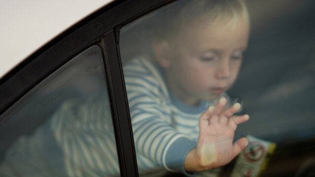  Child trapped in a car on a hot day. Conceptual image of overheating danger in the car for young children in summer 