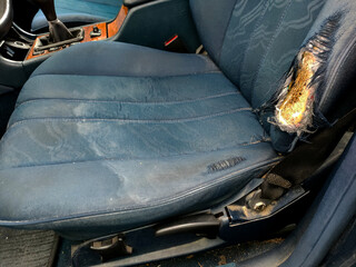 blue car seat with torn upholstery, from long use