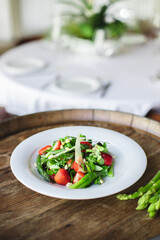 Healthy food, seasonal spring salad, green asparagus, arugula, fresh and healthy vegetables and fruits, herbs, homemade salad.