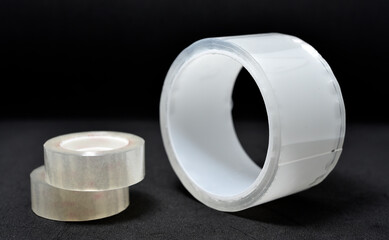 Adhesive tape on a black background. Rolls of transparent tape. Scotch tape on a black background.