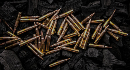 Cartridges for automatic carbine caliber .223 on charcoal. Ammunition for automatic and semi-automatic rifles. Dark back.
