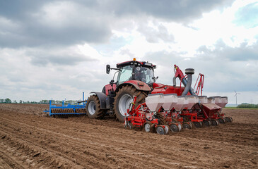 Modernes Maislegen - Traktor mit Lanmaschinen - vorne wird der Boden gelockert, hinten legt die...