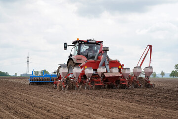 Modernes Maislegen - Traktor mit Lanmaschinen - vorne wird der Boden gelockert, hinten legt die Drillmaschine den Mais.