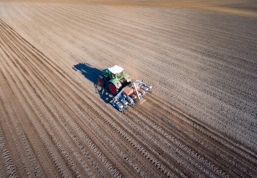 Drohnenfoto: Traktor mit Drillmaschine am Maislegen.