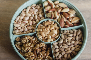 Mix of nuts in a container on a wooden table