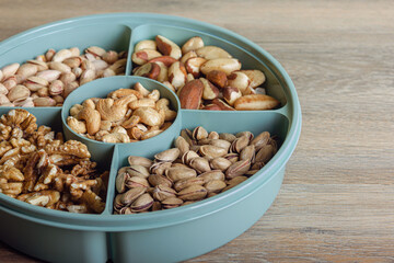 Mix of nuts in a container on a wooden table