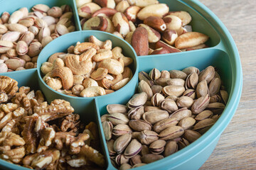 Mix of nuts in a container on a wooden table