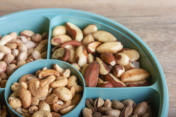 Mix of nuts in a container on a wooden table