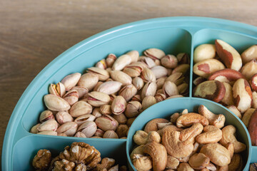 Mix of nuts in a container on a wooden table