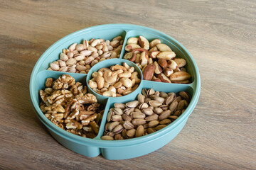 Mix of nuts in a container on a wooden table