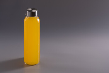 Orange juice bottle on a grey background. The concept of healthy diet. 