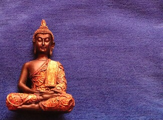 golden buddha statue against a blue background