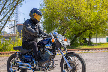 Fototapeta na wymiar male motorcyclist with custom bobber type motorcycle outdoors in summer