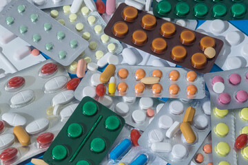 A large pile of pills in bundles scattered on the table