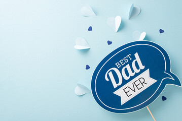 Father's Day theme top view flat lay with a greeting card and paper hearts on a pastel blue backdrop with a blank space for text or advertisement