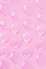 round drops of transparent gel serum on a pink background. gel with bubbles. Water droplets