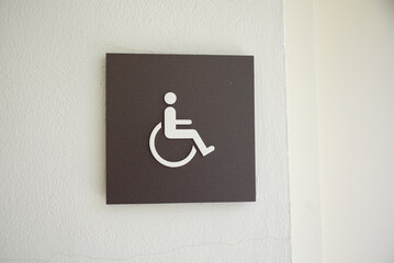 Restroom sign with figures of a girl, guy, and handicap symbol depicts gender and accessibility....