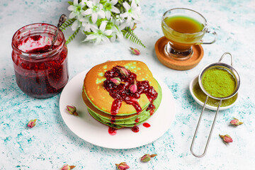 Green pancakes with matcha tea, Ideas and recipes for healthy breakfast with super food ingredients, Matcha green tea and matcha green crepes on grey wooden table with marble background, copy space.