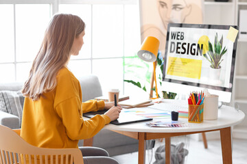 Female graphic designer working with tablet at table in office