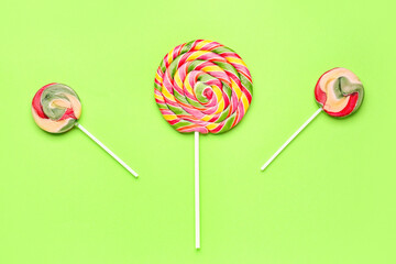 Sweet colorful lollipops on green background