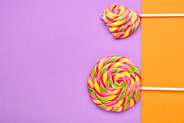 Whole and bitten lollipops on colorful background