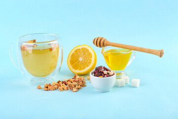 Composition with glass of fruit tea, sugar, lemon and honey on blue background