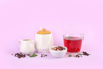 Composition with bowl of dried fruit mix and tea set on pink background