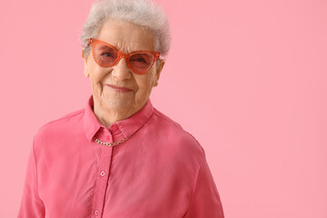 Senior woman on pink background, closeup