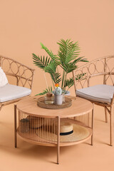 Wooden coffee table with houseplant and cozy armchairs on beige background
