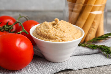 Bowl with tasty hummus on table, closeup