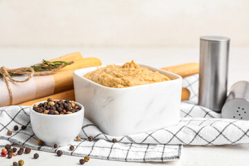 Bowl with tasty hummus on light background