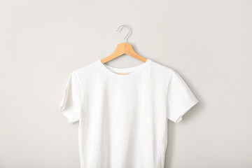 White t-shirt hanging on grey wall