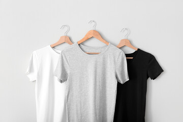 Obraz premium Stylish t-shirts hanging on grey wall