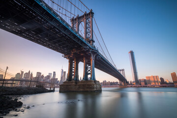 Fototapeta na wymiar Manhattan Bridge seen from the coast next to the D.U.M.B.O area, during dusk with completely clear skies
