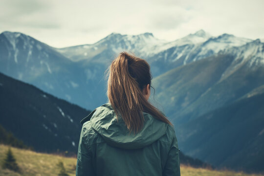 Young woman admiring beautiful mountains, back view. Generative AI