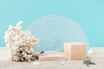 Decorative plaster podiums and coral in sand on turquoise background