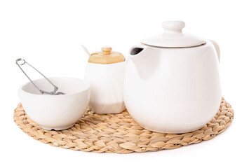 Wicker mat with teapot, cup and sugar bowl isolated on white background