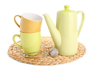 Wicker mat with teapot, mugs and infuser isolated on white background