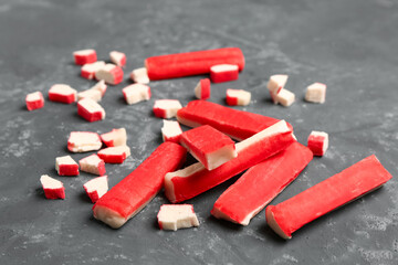 Tasty cut and whole crab sticks on green background © Pixel-Shot